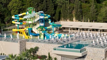 Relax by the large pool surrounded by lush gardens and a multi-level water slide structure.