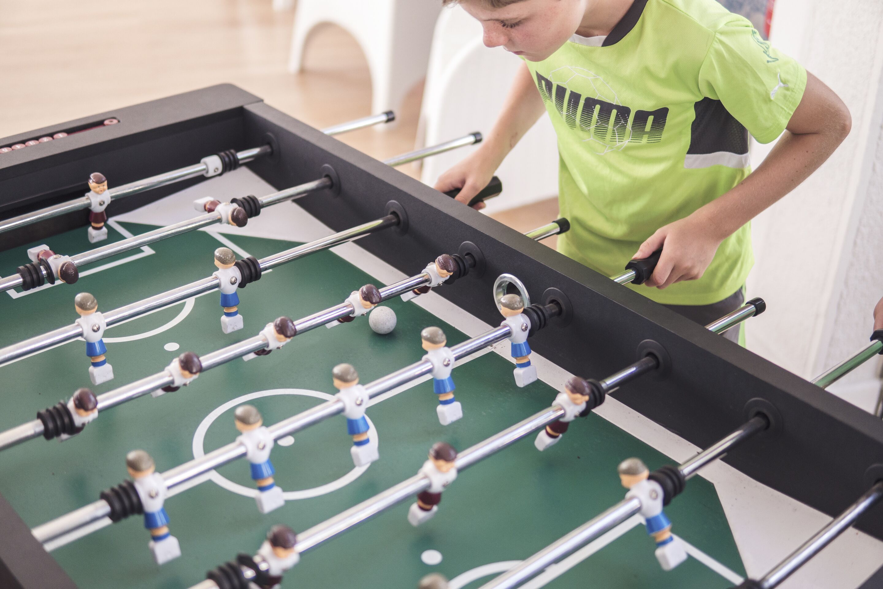 Una mesa de fútbol de mesa con figuras y una pelota en movimiento.