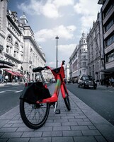 Una bicicleta roja estacionada en una acera de la ciudad.