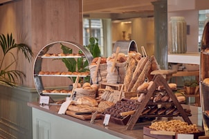 A bakery display with various breads and pastries.