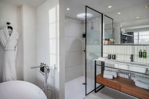 Ein modernes Badezimmer mit Duschkabine aus Glas, einem Holzwaschtisch und einem großen Spiegel.