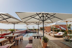 Una piscina al aire libre de temporada, sombrillas
