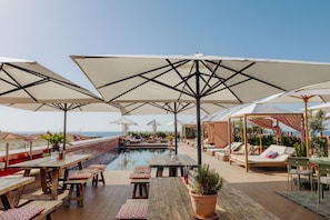 Una piscina al aire libre de temporada, sombrillas