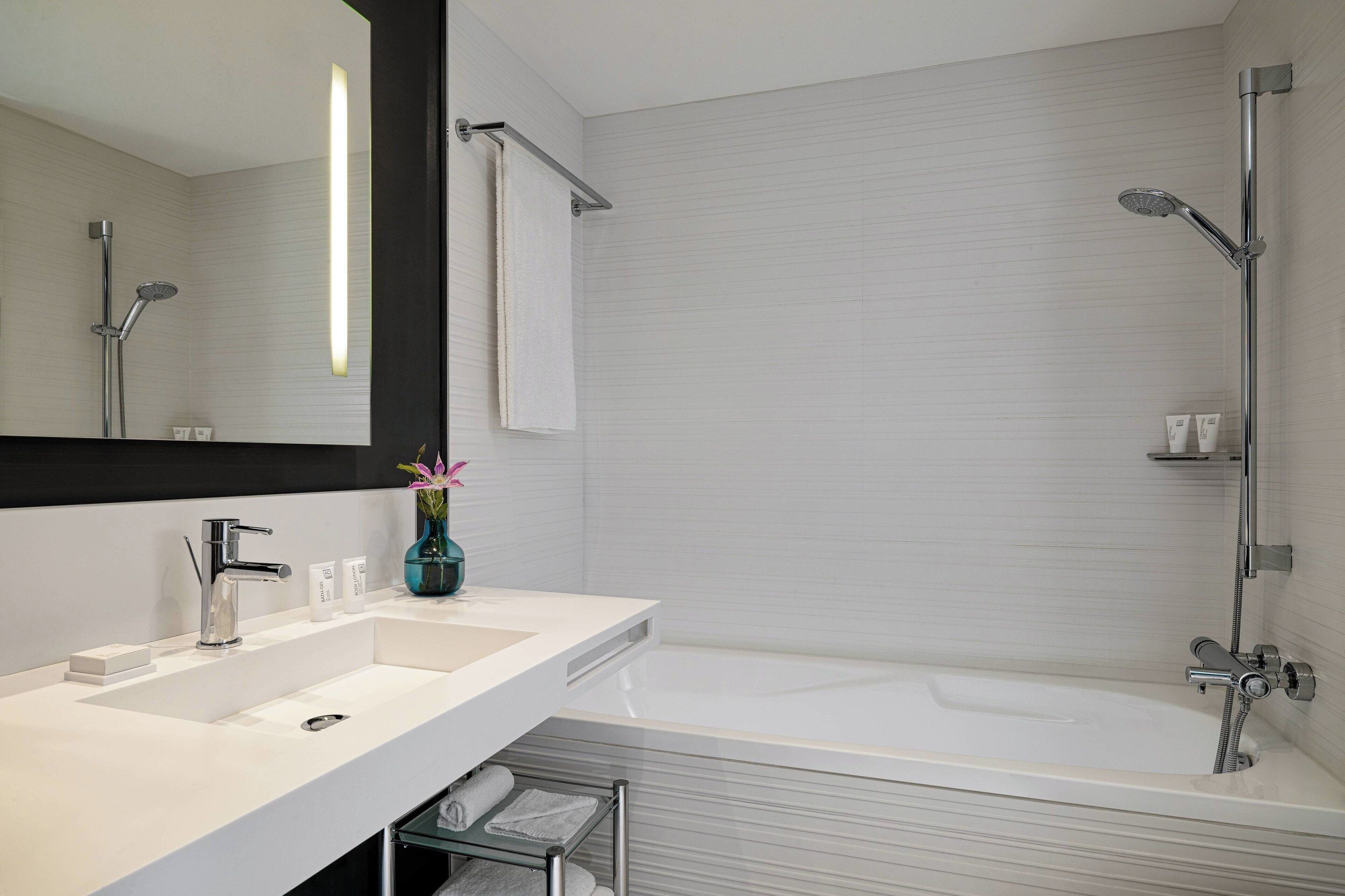 Ein modernes Badezimmer mit Waschbecken, Spiegel und Badewanne.