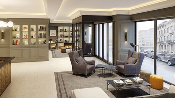 A modern hotel lobby with a seating area, a bookshelf, and a view of the street. - Hotel Avenue Louise Brussels - Trademark Collection by Wyndham (Brussels)