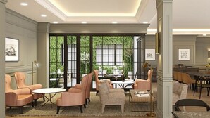 A spacious hotel lobby with large windows, comfortable seating, and a dining area. - Hotel Avenue Louise Brussels - Trademark Collection by Wyndham (Brussels)