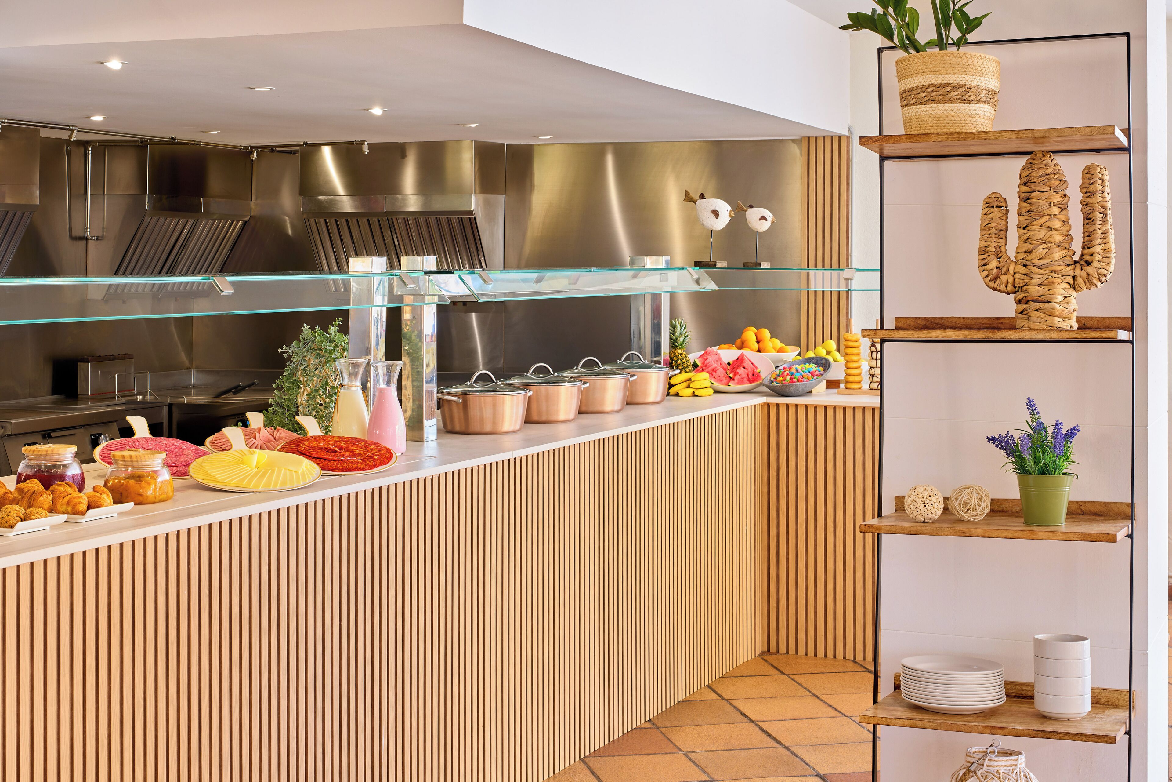 Un espace buffet proposant une variété de plats, une vitrine réfrigérée et des plantes décoratives.