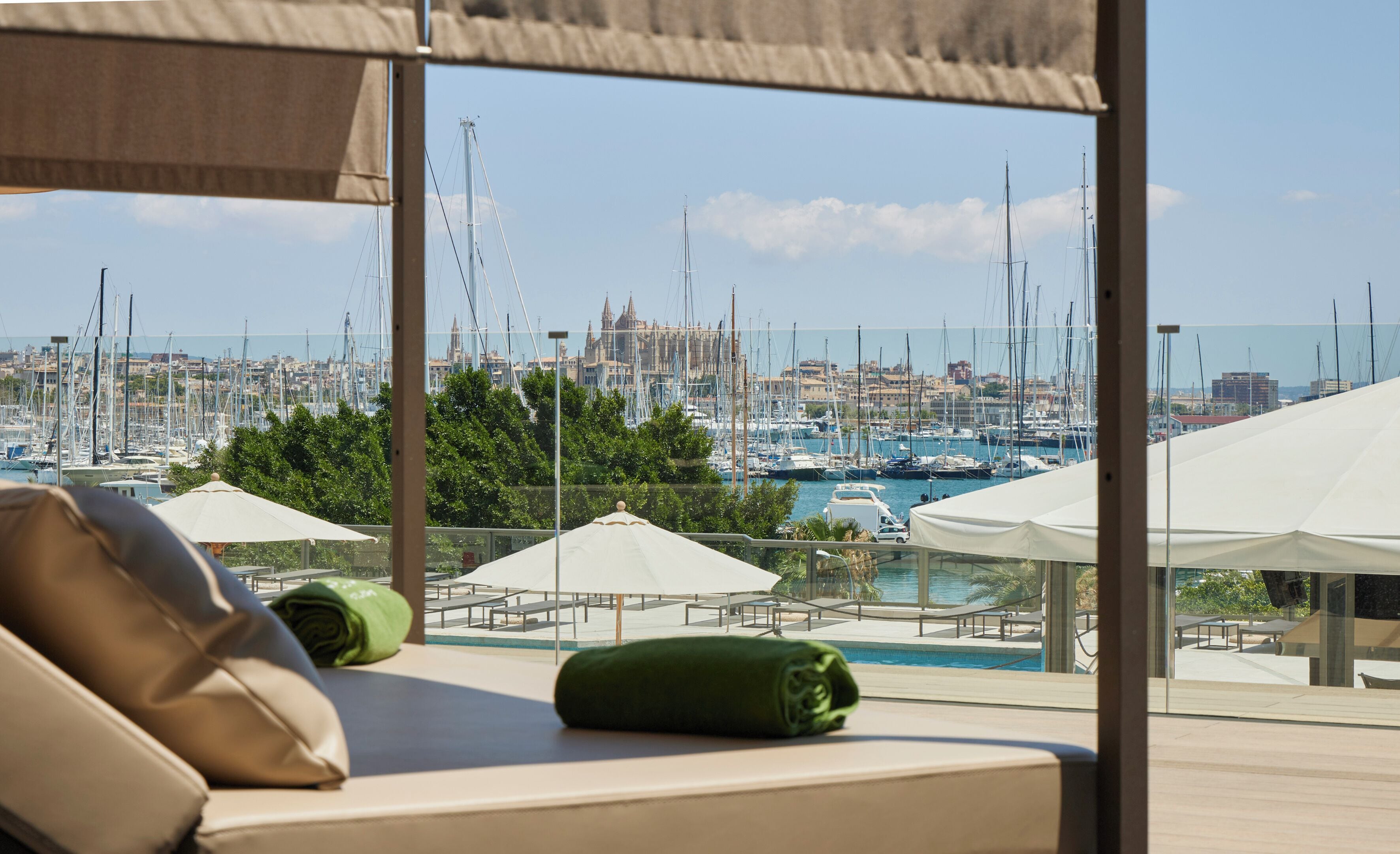 A hotel room with a view of a marina, outdoor seating, and a pool.