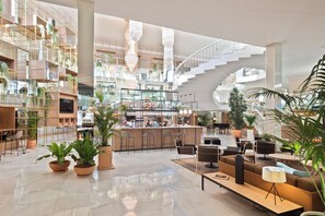 Un vestíbulo amplio con área de bar, asientos y una escalera.