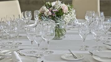 A table set for a formal event with multiple wine glasses, plates, and cutlery.