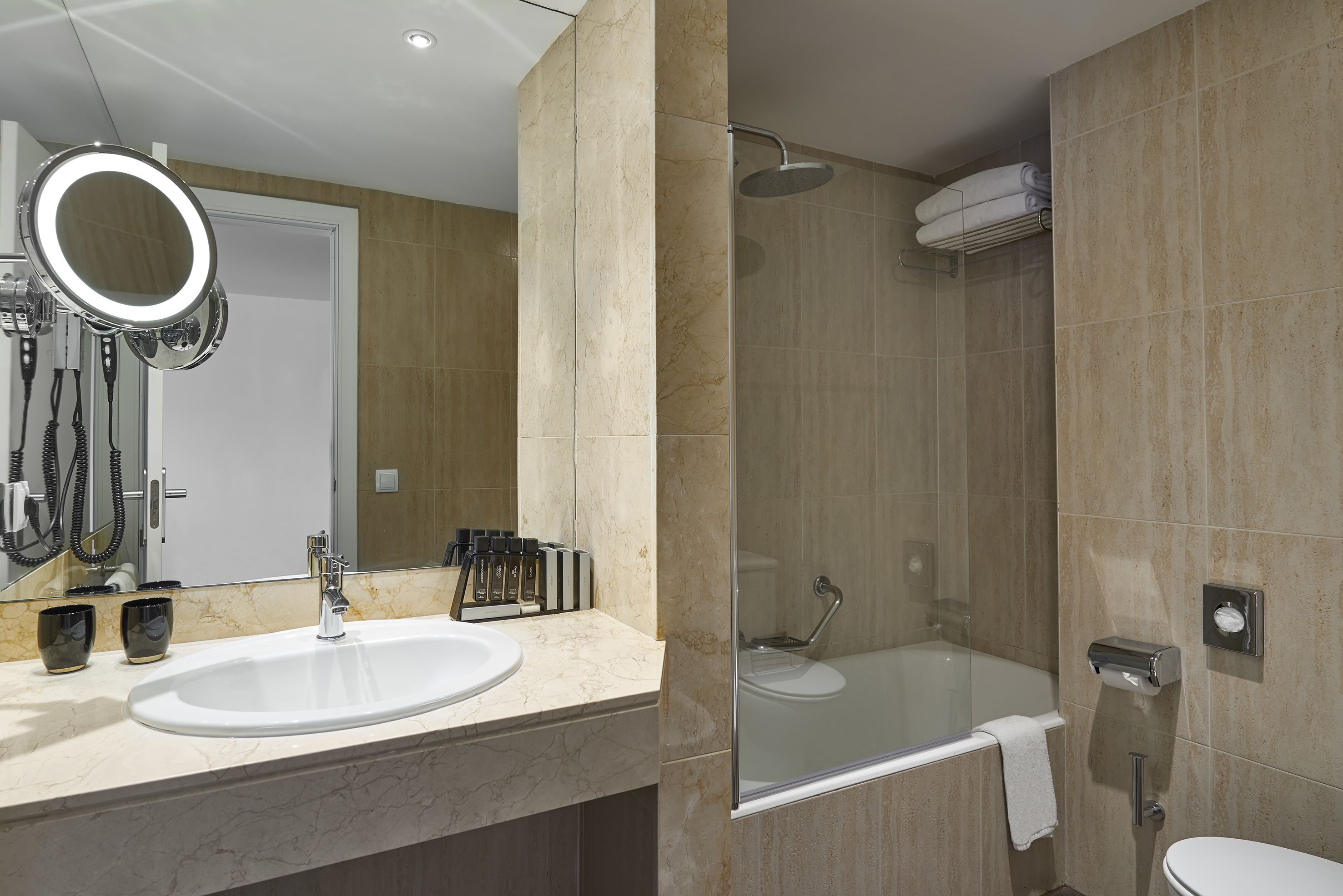 A bathroom with a sink, mirror, and shower.
