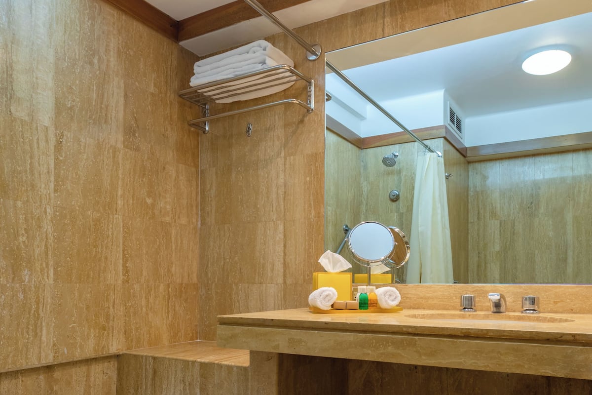 Ein Badezimmer mit einem Holz-Waschtisch, einer Badewanne und einem Spiegel.