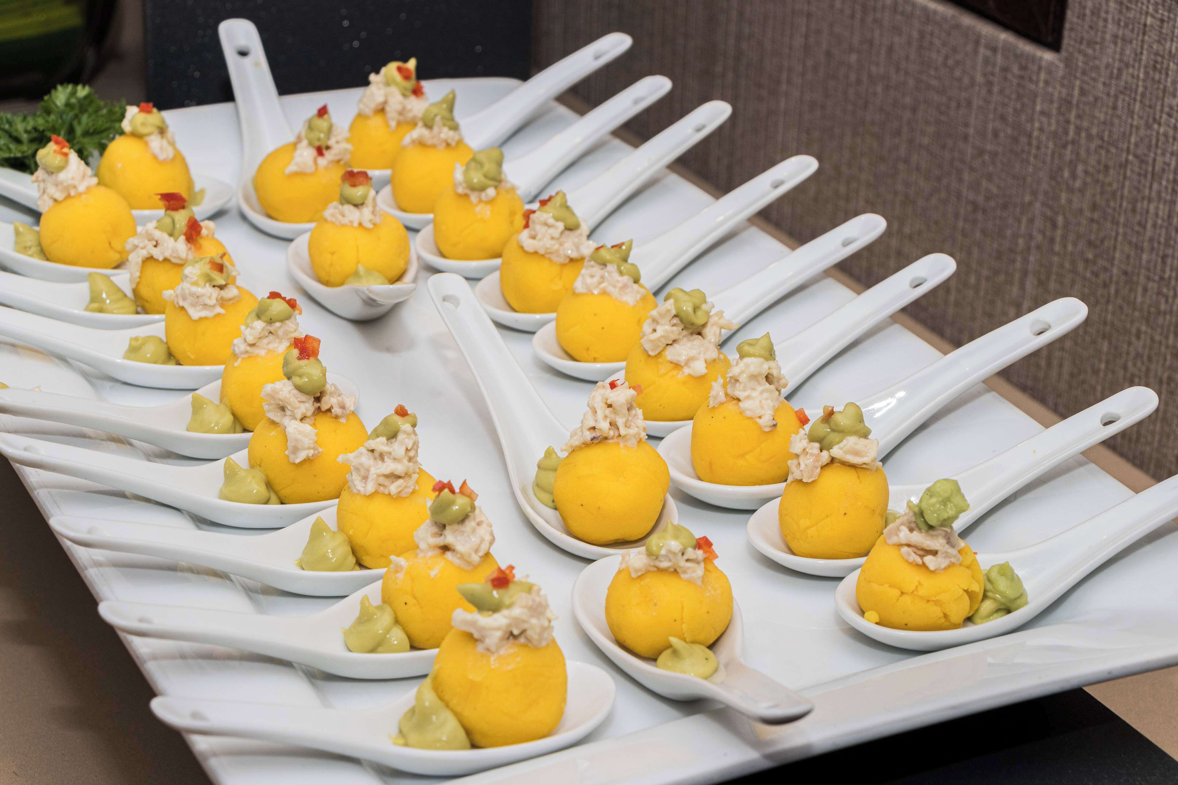 Une assiette contenant divers aliments, présentés sur des cuillères blanches.
