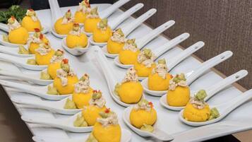 A tray of food items arranged on white spoons.