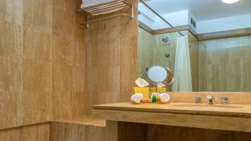 Un baño con bañera, tocador de madera con espejo y zona de ducha.