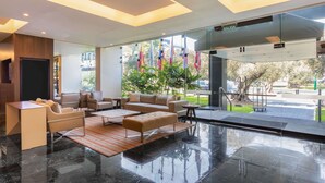 Un vest íbulo moderno con zona de estar, entrada de cristal y vistas al exterior.