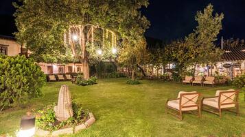 An outdoor seating area with chairs and a decorative tree structure.