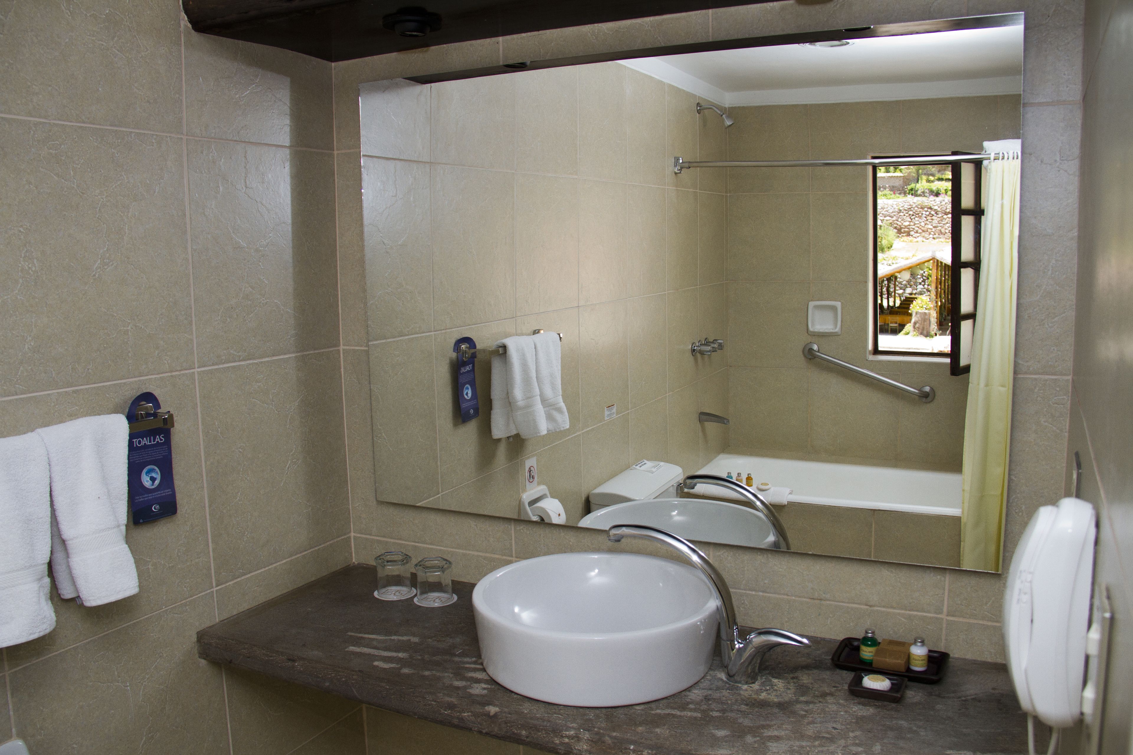 A bathroom with a sink, mirror, and shower.