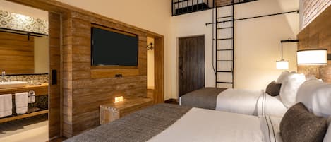 A hotel room with a wooden wall, a TV, a balcony, and a bed with pillows.