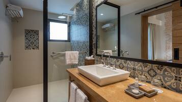 Une salle de bain moderne avec un grand miroir, un lavabo et une douche.