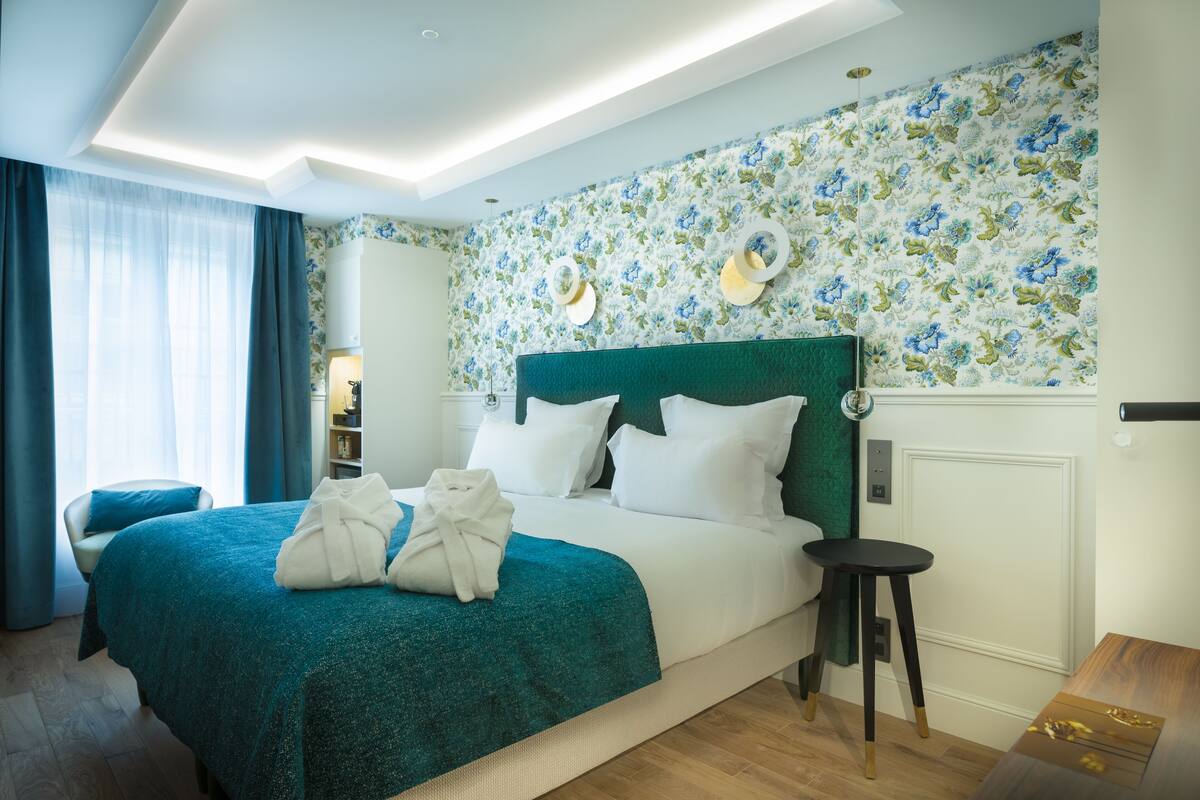 Een hotelkamer met een groot bed, een nachtkastje, een stoel en een kledingkast.