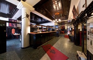 A bar area with a long counter, a red carpet, and a column. - Hotel Ahl Meerkatzen (Cologne)