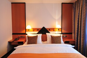 Relax in comfort with a large bed, two nightstands, and a stylish headboard.