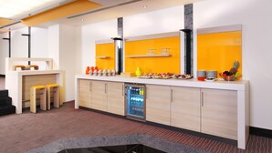 Un área de recepción moderna con mostrador, asientos y dispensador de bebidas.