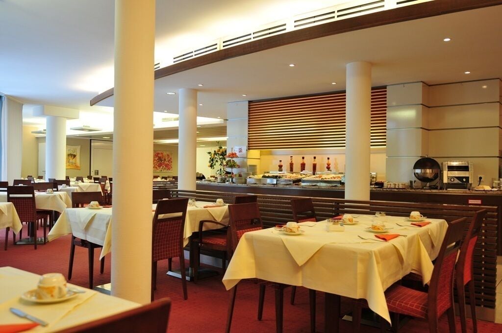 Een restaurant met gedekte tafels, een buffet en een bar.