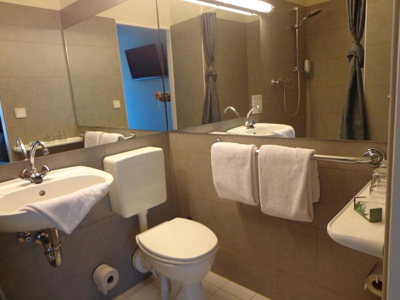 Ein modernes Badezimmer mit Toilette, Waschbecken und Dusche.