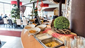 A buffet area with various food items and a decorative plant centerpiece. - Hotel Am Wall Soest (Soest)