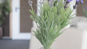 Un jarrón de vidrio transparente con flores de lavanda sobre una bandeja.