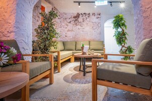 Un'accogliente zona relax con mobili in legno, un divano verde e piante in vaso.