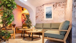A cozy room with a wooden sofa, a round table, and a potted plant.
