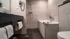 A modern bathroom with a shower, sink, and toilet. - Hotel Am Stadtpark (Hilden)