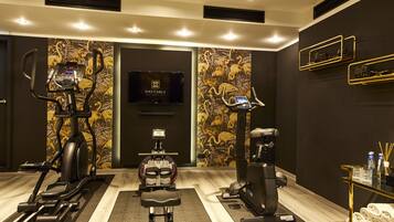 Un gimnasio de hotel con cintas de correr, una elíptica y una bicicleta estática.