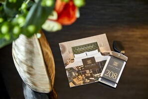 Un folleto del Hotel Das Carls, que muestra la distribución de una habitación con cama, escritorio y silla.
