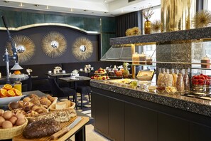 A breakfast buffet with various food items and a modern interior design. - Das Carls Hotel (Düsseldorf)