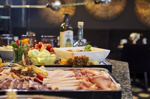 Un buffet con diverse carni, insalate e salse.