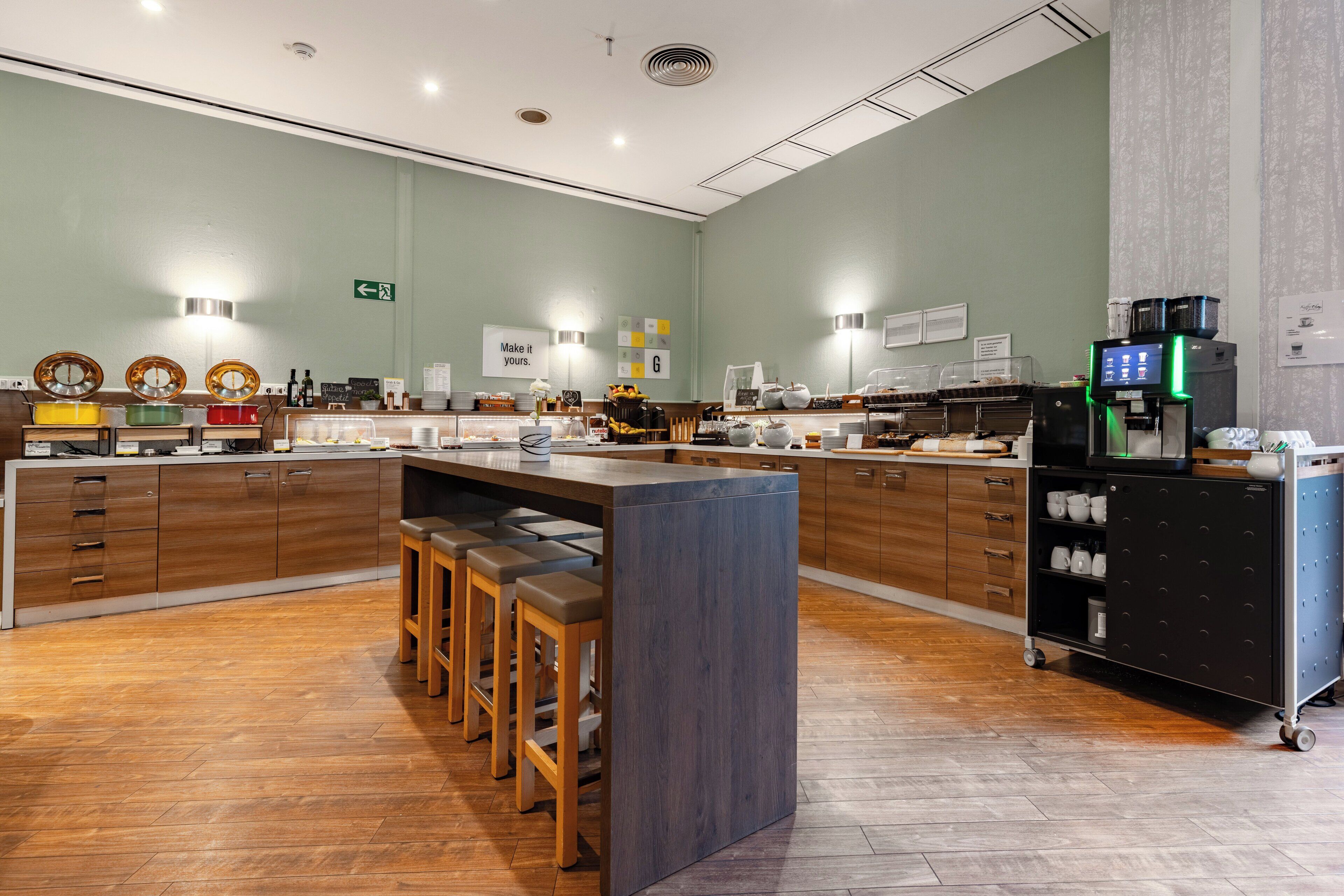 A modern cafe with a central island, bar stools, wooden cabinets, and a coffee machine.