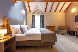 Una camera da letto con un letto, un comodino, una lampada e un televisore appeso al muro.