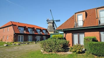 Traditional windmill and charming brick buildings set amidst well-maintained gardens.