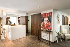 Un espacio habitable moderno con cocina, una mesa de comedor y una zona de estar con sofá y sillón.