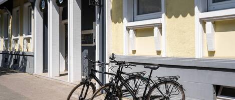 A bicycle parked outside a building with a sign that reads 'ARTHOTEL ANA EDEN KARLSRUHE.'