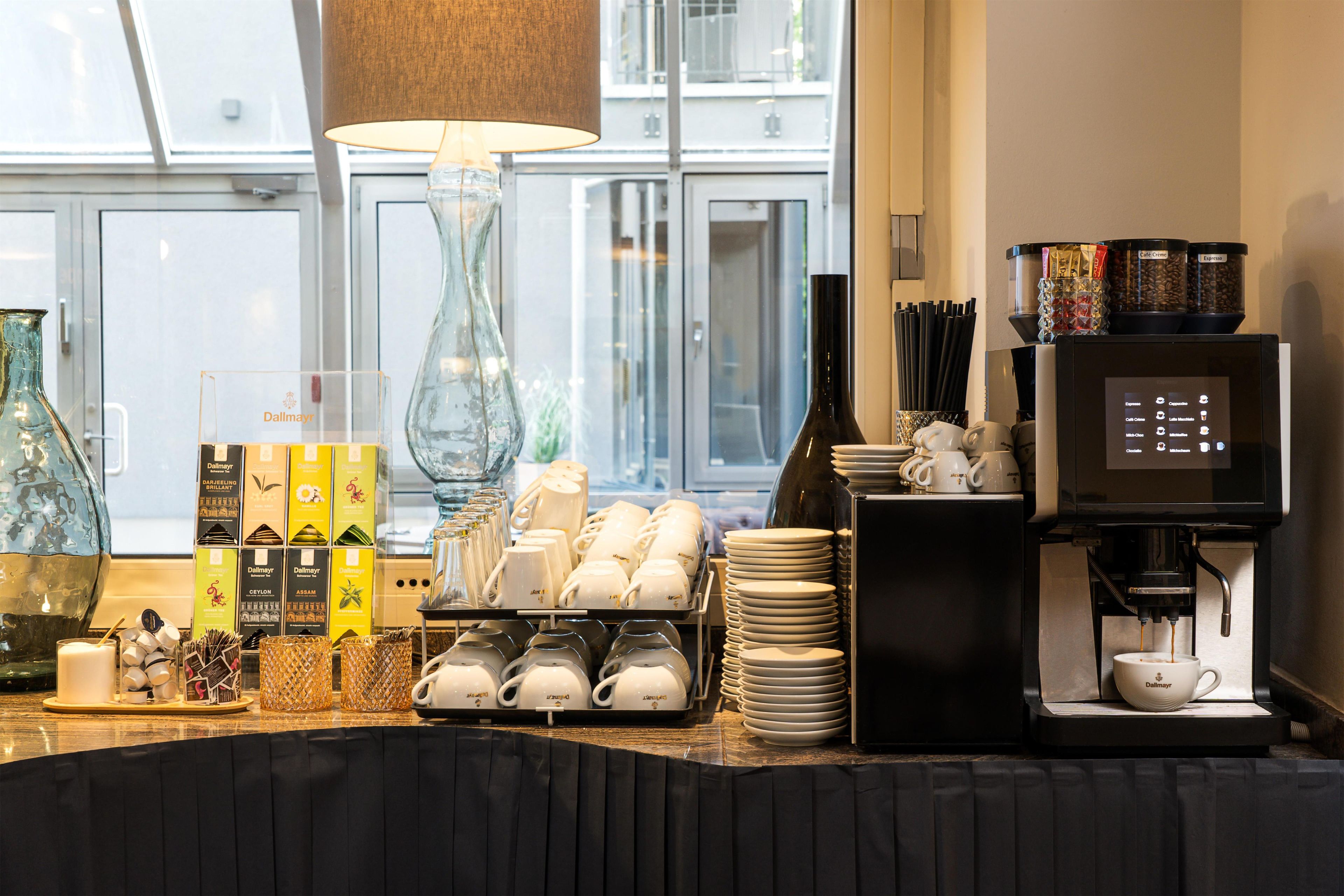 Zona de cafè amb una màquina de cafè, tasses i diverses infusions.