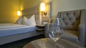 Une chambre d’hôtel avec un lit, une table de chevet, une lampe et un verre posé sur une table en bois.