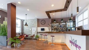 A modern bar area with a clock, bar stools, and a bar counter. - Mercure Hotel Frankfurt City Messe (Frankfurt)