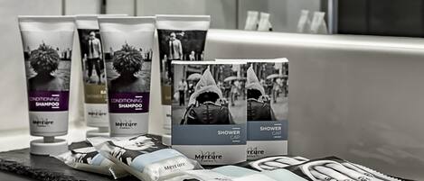 Un baño con artículos de aseo, incluyendo botellas de champú y gorros de ducha.