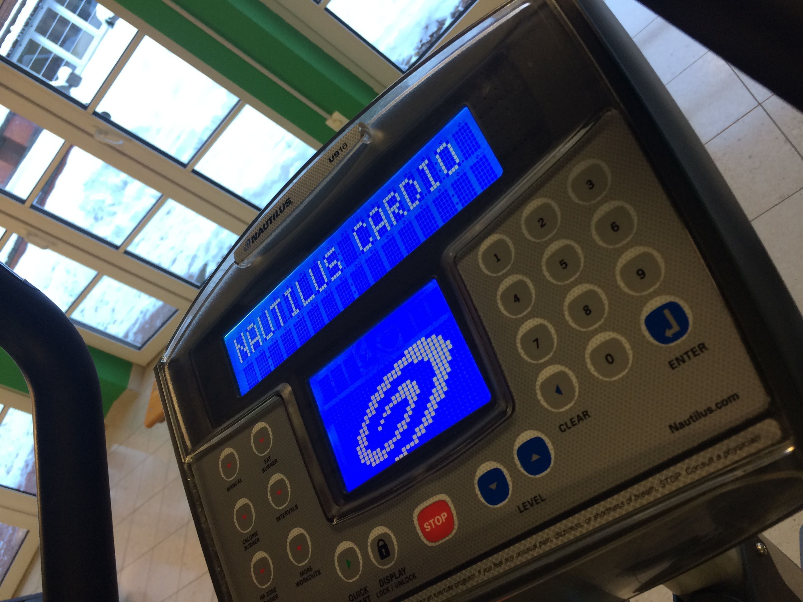 Una máquina de cardio Nautilus con pantalla digital, botones de control y una pantalla que muestra un monitor de frecuencia cardíaca.