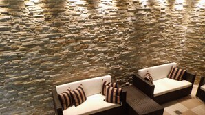 A stone wall with a seating area featuring two sofas and a coffee table. - relexa hotel Harz-Wald (Braunlage)